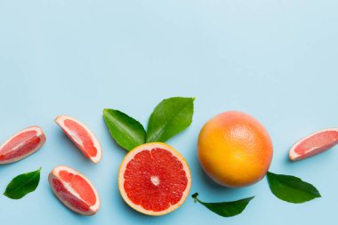 Renkli arka planda sulu greyfurt dilimli taze meyve greyfurdu. Üst Manzara. Uzayı kopyala yaratıcı yaz konsepti. Minimum düzlükte turunçgillerin yarısı kopyalama alanı ile yatar.