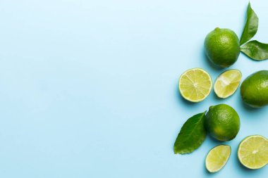 Yeşil yapraklı kireç meyveleri ve beyaz arka planda yarım dilim kesilmiş. Üst Manzara. Kopyalama alanı olan düz.