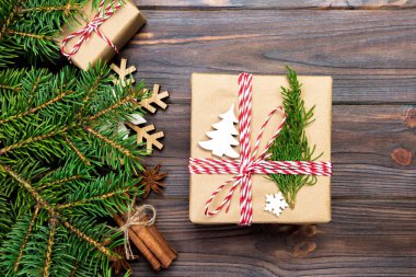 Noel köknar ağacı ve hediye kutusu ahşap masa üzerinde arka plan. Tasarımınız için kopya alanı ile üstten görünüm.