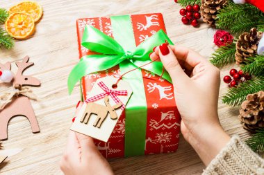 Kadın eli görüntüsü, yeni yılı şenlikli ahşap arka planda kutluyor. Firavun ağacı ve tatil süslemeleri. Noel zamanı konsepti.