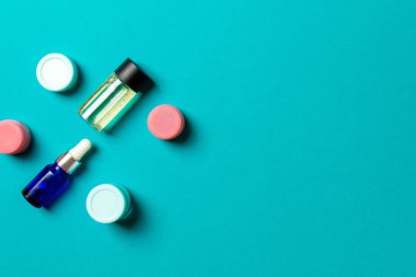 Kozmetik SPA marka modeli, fotokopi alanı olan üst görünüm. Renkli arka planda duran krema tüpleri ve kavanozları..