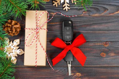 Araba anahtarı hediye kutusu ahşap arka plan üzerinde renkli yay ile.
