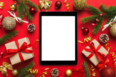 Digital tablet mock up with rustic Christmas decorations for app presentation top view with empty space for you design. Christmas online shopping concept. Tablet with copy space on colored background.