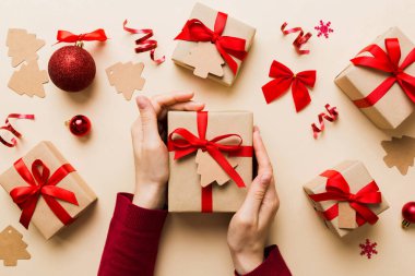 Kadın eli hediye kutusunu tutuyor, sürprizi hazırlıyor, üst manzara, Noel ve yeni yıl konsepti.