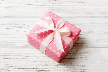 Noel 'i ya da diğer tatil hediyelerini renkli arka planda kurdeleyle renkli kağıda sardım. Şimdiki kutu, renkli tabloda hediye süslemesi, kopya alanı ile üst görünüm.