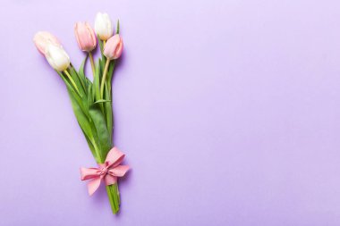 Renkli masa arkasında bir buket pembe lale. Kopyalama alanı olan üst görünüm. Baharı bekliyorum. Mutlu Paskalyalar. Düz yatıyordu.