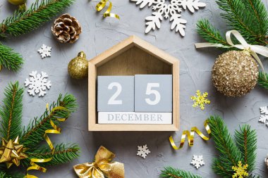Christmas calendar 25 december. Christmas gift, fir branches, pine cones. Flat lay, top view. New Year decorations on a colored background.