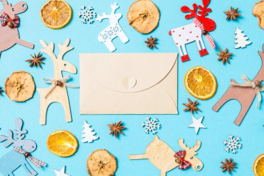 Tatil süslemeleri ve oyuncaklardan yapılmış mavi arka plandaki el sanatları zarfının en üst görüntüsü. Noel süsü konsepti.