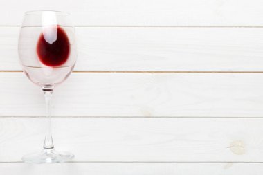 Şarap tadımında bir kadeh kırmızı şarap. Renkli arka planda kırmızı şarap kavramı. Üst görünüm, düz dizayn.