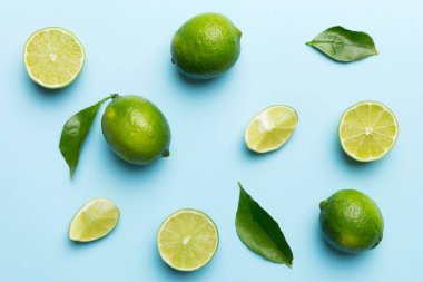 Yeşil yapraklı kireç meyveleri ve beyaz arka planda yarım dilim kesilmiş. Üst Manzara. Kopyalama alanı olan düz.