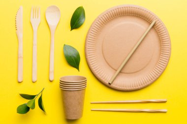 Açık beyaz masa arkaplanındaki boş, tek kullanımlık çevre dostu tabaklar, bardaklar, çatal bıçaklar. Üst Manzara. Biyo-çözünebilir el yapımı yemekler. Geri dönüşüm konsepti. Yakın plan..