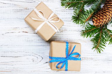 Noel hediye kutusu beyaz ahşap masa arka plan, Ladin şube, çam kozalakları, çerçeve, üstten görünüm, metin için yer.