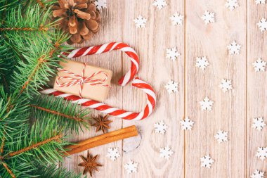 Noel hediyesi kutusu, kar taneli şeker kamışı ve ahşap masada köknar ağacı dalı. Ayarlanmış.