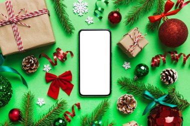 Digital phone mock up with rustic Christmas decorations for app presentation top view with empty space for you design. Christmas online shopping concept. Tablet with copy space on colored background.