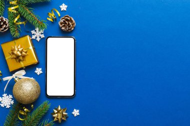 Digital phone mock up with rustic Christmas decorations for app presentation top view with empty space for you design. Christmas online shopping concept. Tablet with copy space on colored background.