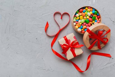 Valentine day composition: sweet candy, with gift boxes with bow and red felt hearts, photo template, background. Top View with copy space.