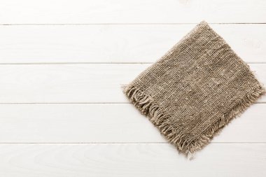 Old burlap fabric napkin, sackcloth on table background. top view with copy space.