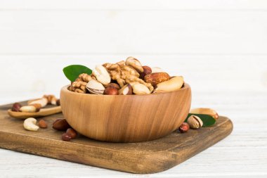 mixed nuts in bowl. Mix of various nuts on colored background. pistachios, cashews, walnuts, hazelnuts, peanuts and brazil nuts.