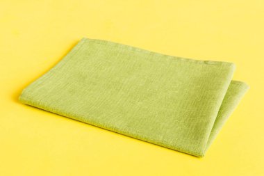 top view with green kitchen napkin isolated on table background. Folded cloth for mockup with copy space, Flat lay. Minimal style.