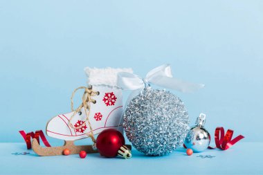 Christmas ball with skates on colored background. decoration bauble with ribbon bow with copy space.