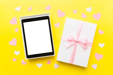 Gift box of open tablet for the holidays with a bow top view.