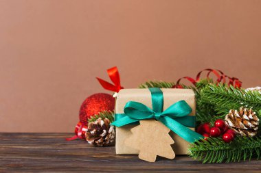 New Year Christmas mood, gift box, branches of a christmas tree, New Year decorations on a colored background.