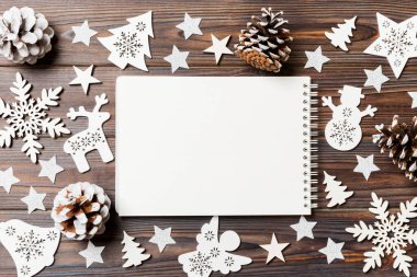 Noel süslemelerinden yapılmış ahşap arka plandaki defterin en üst görüntüsü. Yeni yıl konsepti.