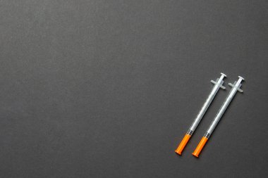 Renkli arka planda fotokopi alanı olan iki insülin şırıngasının üst görüntüsü. Yüksek seviyedeki glikoz konsepti.