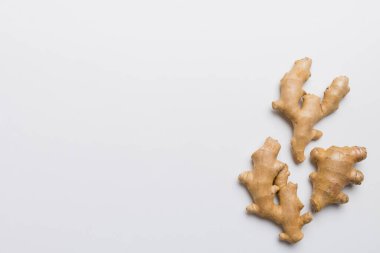 Renkli arka planda yeşil yapraklı kabın içinde zencefil tozu var. Üst görünüm düzlüğü.