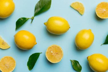 Renkli arka plan olarak pek çok taze limon, üst manzara. Limon ve limon dilimlerinin zarif arka planı Üst görünüm düz yatıyordu.