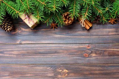 hediye da tarçın sopa, Anason yıldız, çam kozalakları ve çam dalları ahşap masa üzerinde. Üstten görünüm. Noel hediyeleri woodan tarzı.