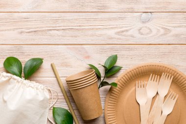 Açık beyaz masa arkaplanındaki boş, tek kullanımlık çevre dostu tabaklar, bardaklar, çatal bıçaklar. Üst Manzara. Biyo-çözünebilir el yapımı yemekler. Geri dönüşüm konsepti. Yakın plan..