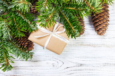 Noel hediye kutusu beyaz ahşap masa arka plan, Ladin şube, çam kozalakları, çerçeve, üstten görünüm, metin için yer.