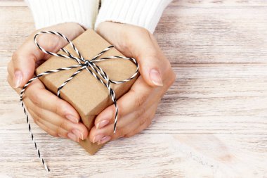 Kadınların elleri Noel 'i ya da yeni yılı süsleyen hediye kutusunu tutar..