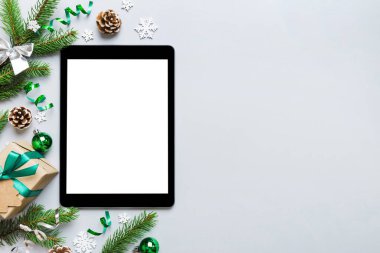 Digital tablet mock up with rustic Christmas decorations for app presentation top view with empty space for you design. Christmas online shopping concept. Tablet with copy space on colored background.