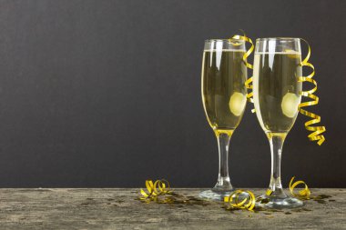 Champagne glasses and christmas decor on colored holiday background. Flat lay New Year decorations.