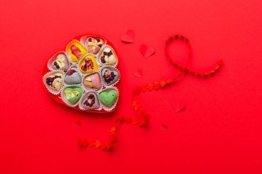 Valentine day composition: sweet candy, with gift boxes with bow and red felt hearts, photo template, background. Top View with copy space.