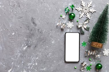 Digital phone mock up with rustic Christmas decorations for app presentation top view with empty space for you design. Christmas online shopping concept. Tablet with copy space on colored background.