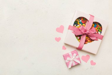 Valentine day composition: sweet candy, with gift boxes with bow and red felt hearts, photo template, background. Top View with copy space.