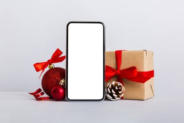 Digital phone mock up with rustic Christmas decorations for app presentation with empty space for you design. Christmas online shopping concept. Tablet with copy space on colored background.