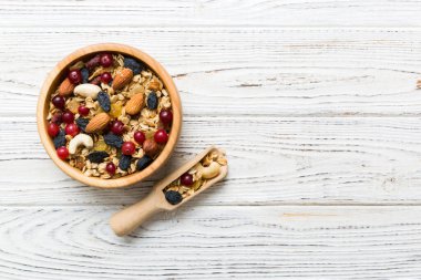 Sağlıklı bir kahvaltı hazırlıyorum. Bir kasede çeşitli kurutulmuş meyve ve fındıklı granola. Sağlıklı tatlı kavramı. Düz konum, kopyalama alanı olan üst görünüm.