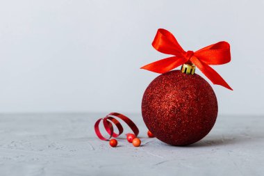 Christmas ball on colored background. decoration bauble with ribbon bow with copy space.