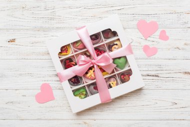 Valentine day composition: sweet candy, with gift boxes with bow and red felt hearts, photo template, background. Top View with copy space.