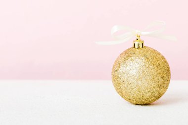 Christmas ball on colored background. decoration bauble with ribbon bow with copy space.