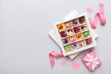 Valentine day composition: sweet candy, with gift boxes with bow and red felt hearts, photo template, background. Top View with copy space.