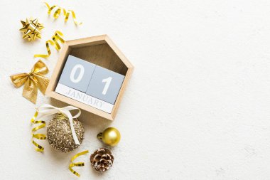 Christmas calendar 1 january. Christmas gift, fir branches, pine cones. Flat lay, top view. New Year decorations on a colored background.