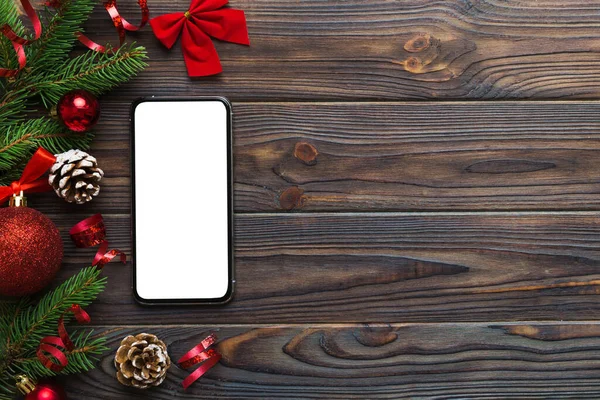 Digital phone mock up with rustic Christmas decorations for app presentation top view with empty space for you design. Christmas online shopping concept. Tablet with copy space on colored background.