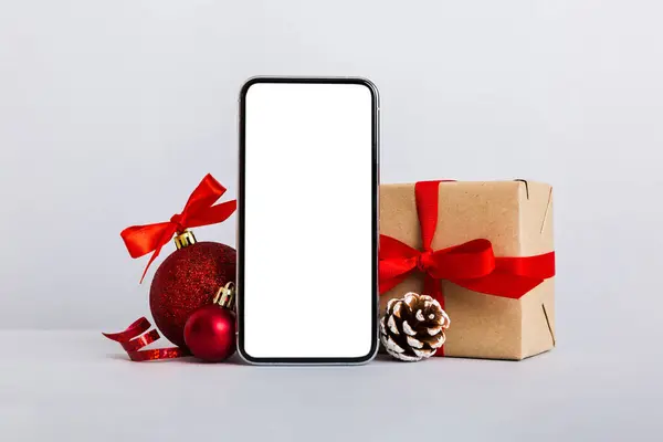 Digital phone mock up with rustic Christmas decorations for app presentation with empty space for you design. Christmas online shopping concept. Tablet with copy space on colored background.