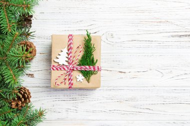 Noel hediye kutusu ile şerit rustik arka plan üzerinde şerit yay ile geri dönüşümlü kağıt sarılı. Tatil kavramı.