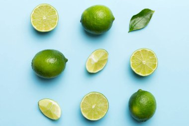 Yeşil yapraklı kireç meyveleri ve beyaz arka planda yarım dilim kesilmiş. Üst Manzara. Kopyalama alanı olan düz.